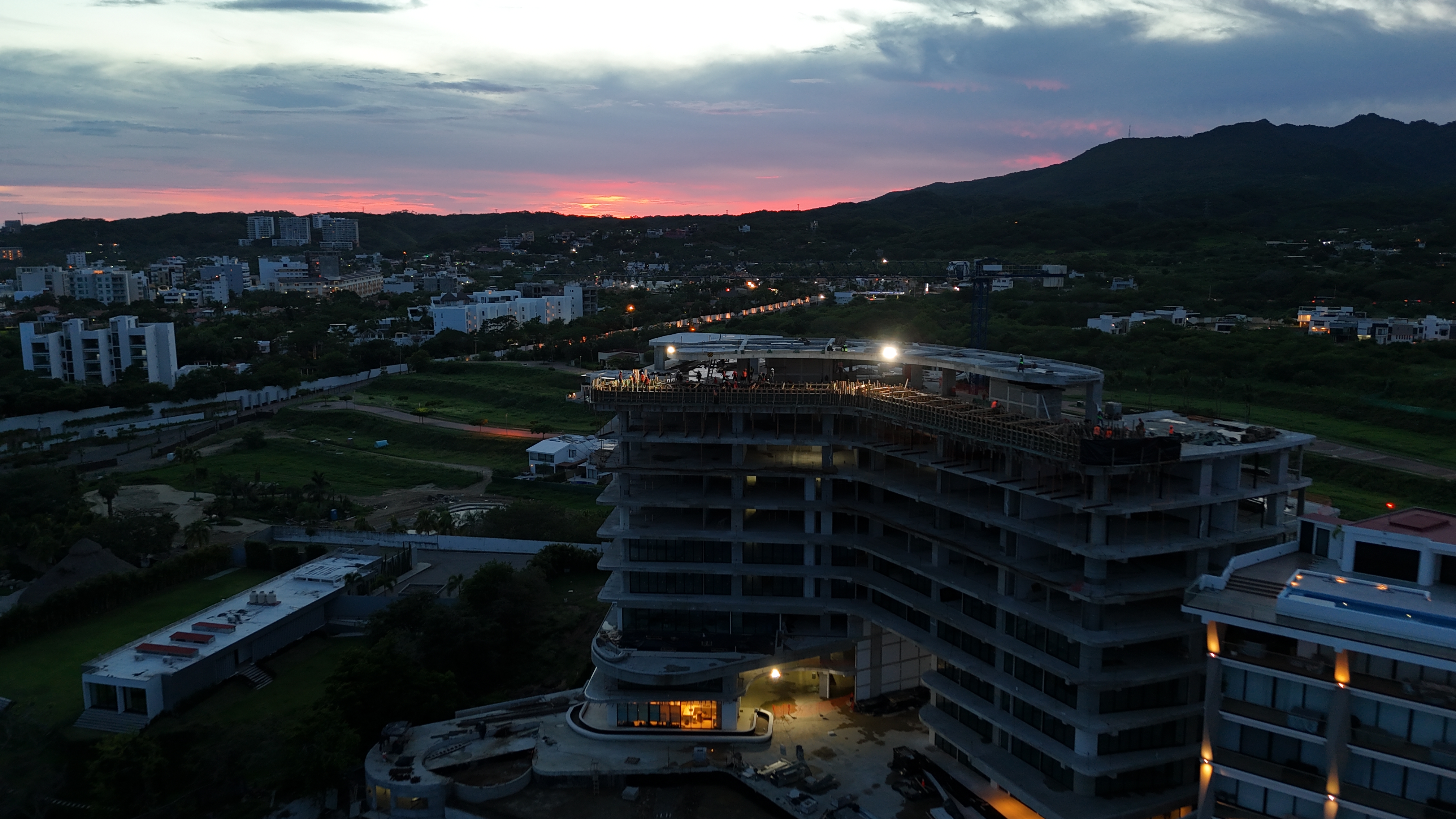 Vista aérea al atardecer de obra de edificio curvo en construcción — AV CONSTRUINSTALACIONES